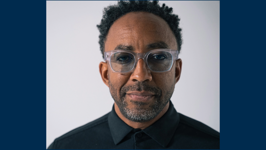 Close-up portrait of man with black shirt and light gray glasses